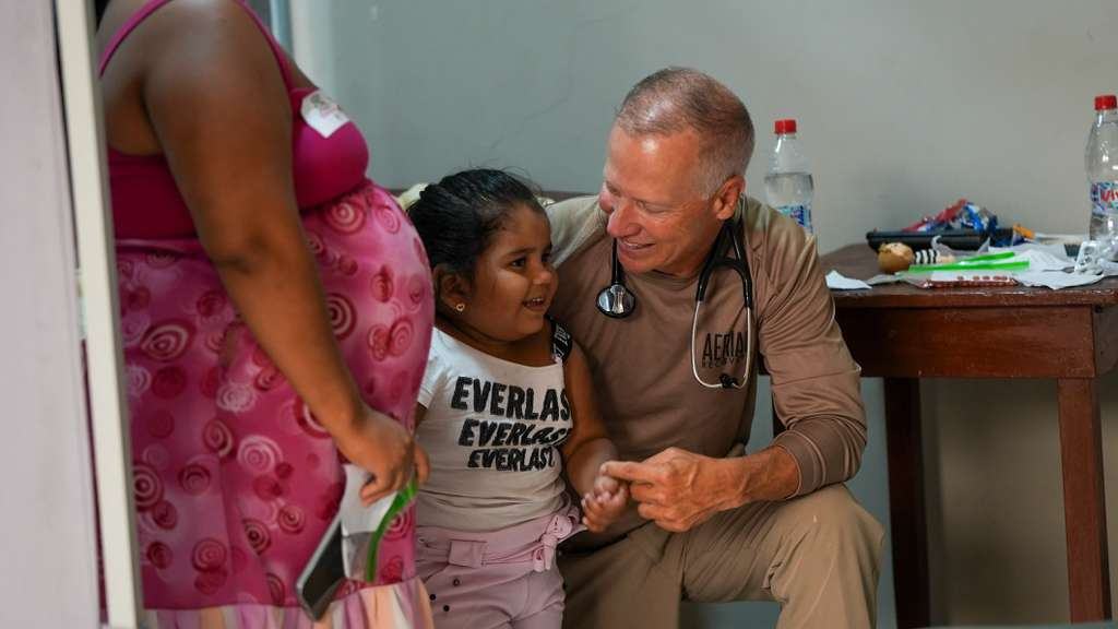 A team physician with a young patient in Canoa