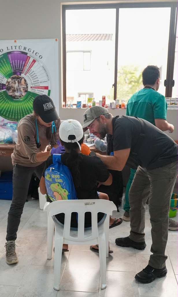 An Aerial Recovery volunteer examining a child patient