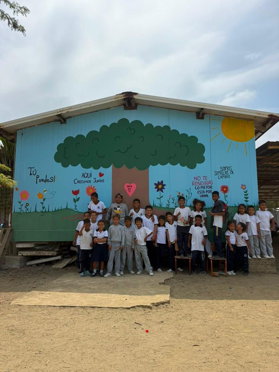 Kids in front of the hand-painted tree mural in Canoa